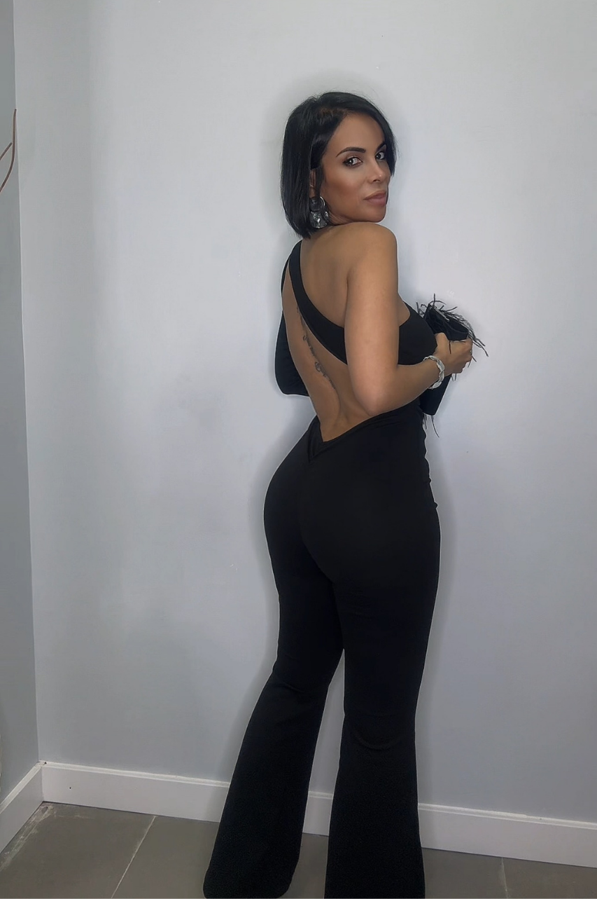 Pilar Mono Negro con Escote Asimétrico, Espalda Descubierta, Cintura con Hebilla y Pantalón de Pierna Ancha