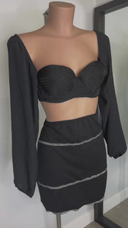 Silvia Conjunto negro de falda y top con mangas abullonadas y espalda con lazo